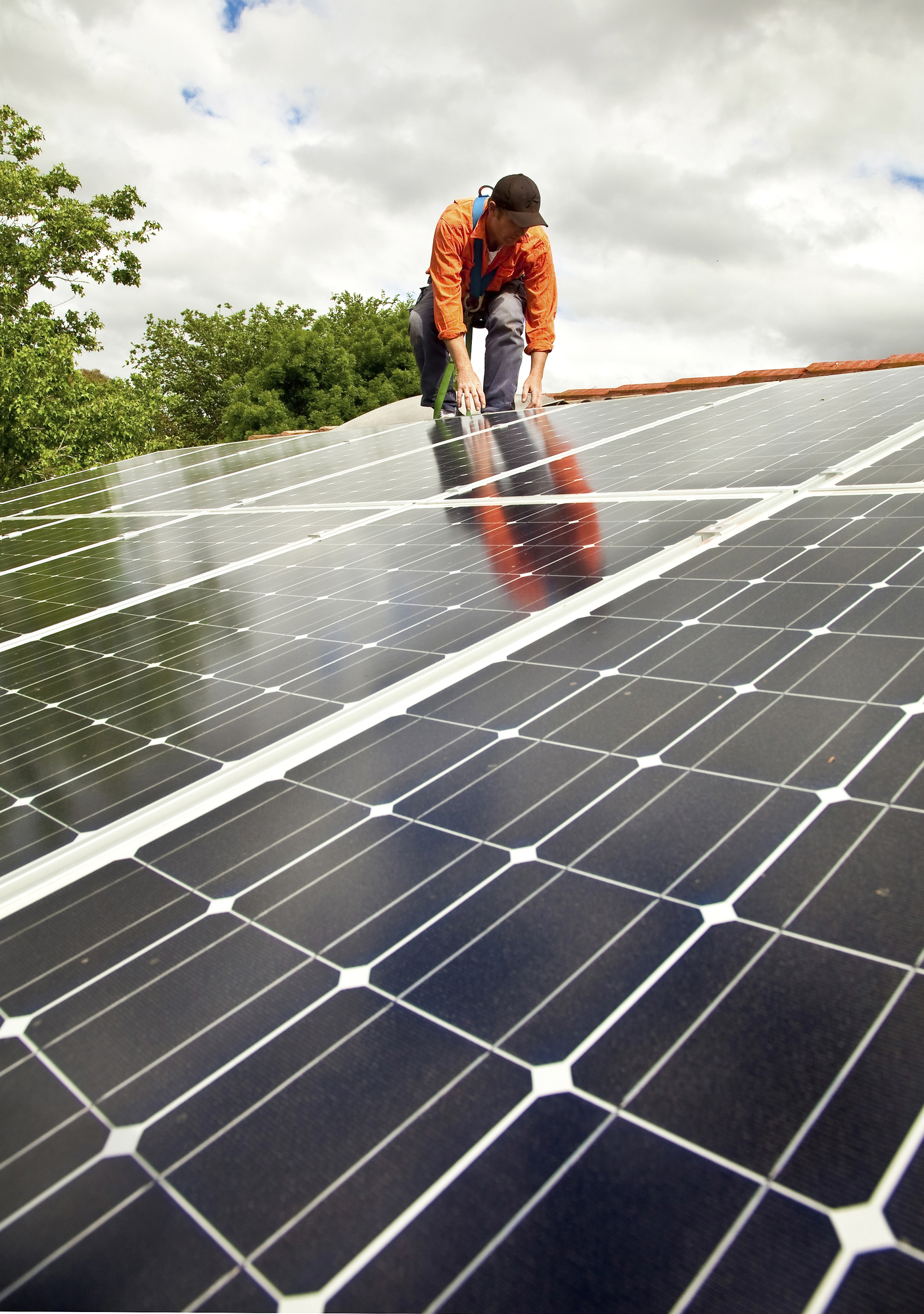 Electrician checking solar panels on roof to harness the energy of the sun